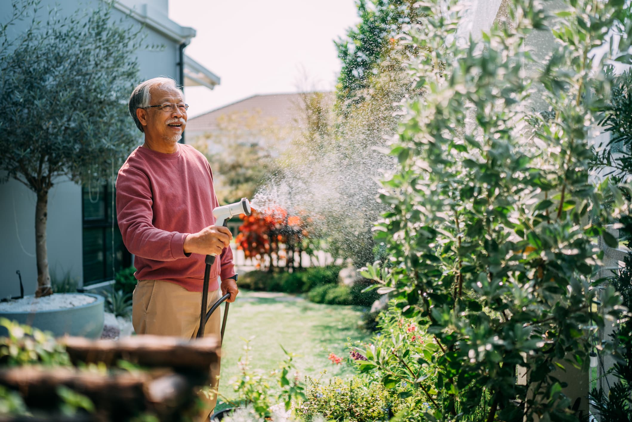 Person watering garden in suburban Columbus neighborhood